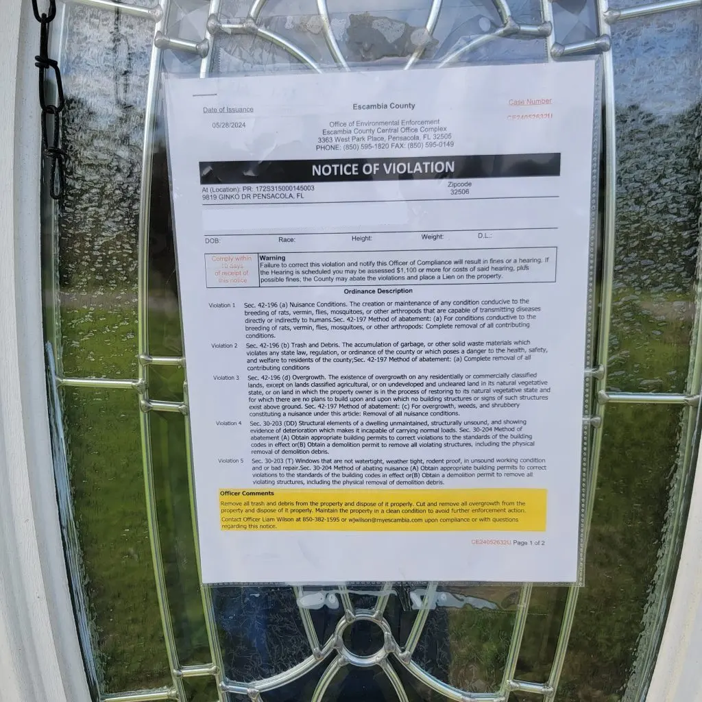 Image of code violation notices on the door of a property.