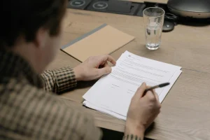 Image of a man filling out documents. We can buy houses for cash fast.