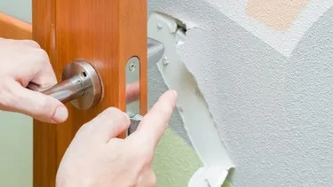 Damaged door frame and lock area showing structural damage to residential entry door